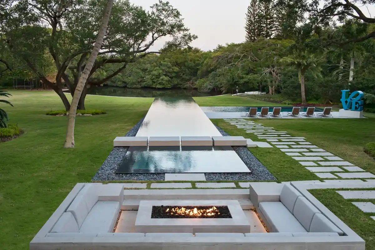 Sunken fire pit lounge in front of a long reflecting water feature at Journeys End